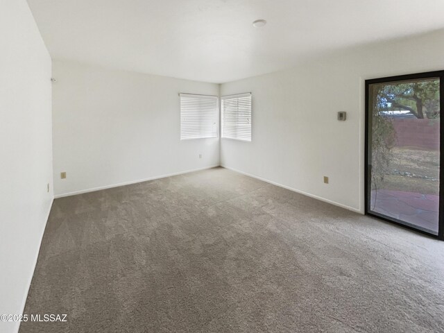 carpeted empty room featuring plenty of natural light and baseboards