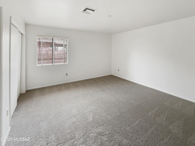 carpeted empty room with visible vents and baseboards