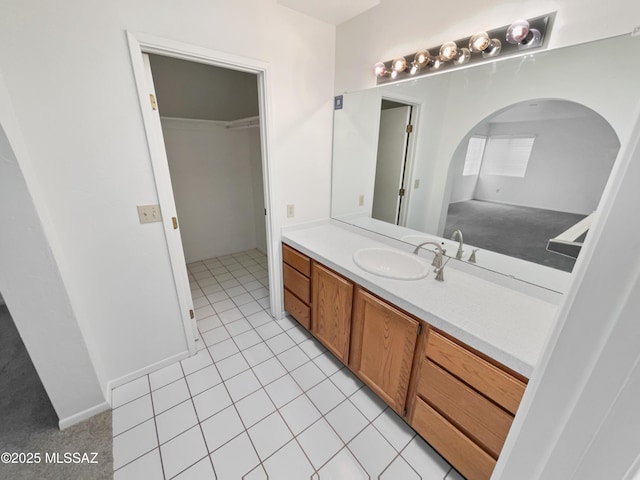 bathroom with vanity, tile patterned flooring, and a walk in closet