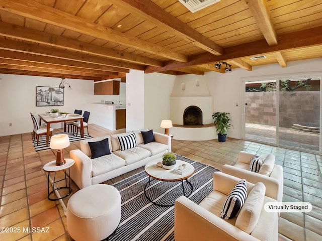 living room featuring visible vents, wooden ceiling, a fireplace, beam ceiling, and light tile patterned flooring