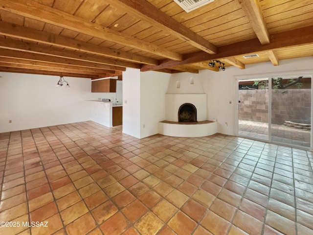 unfurnished living room with visible vents, wooden ceiling, beamed ceiling, a large fireplace, and light tile patterned flooring
