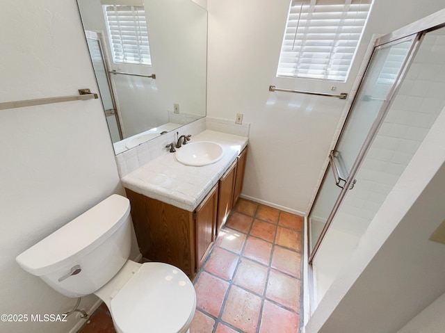 bathroom with tile patterned floors, toilet, vanity, and a stall shower