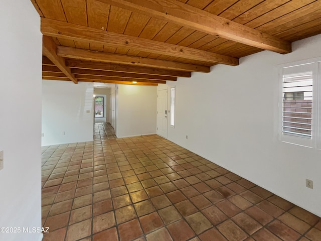 tiled spare room featuring wood ceiling and beam ceiling