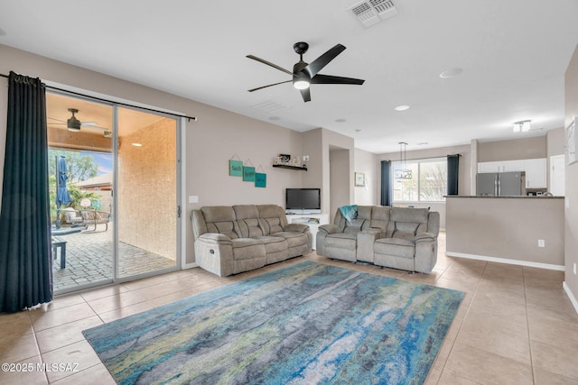 living area featuring visible vents, ceiling fan, and light tile patterned floors