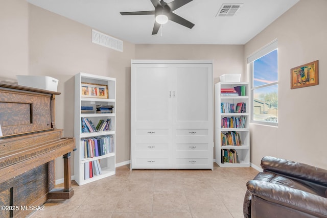 living area featuring visible vents, baseboards, a ceiling fan, and light tile patterned flooring