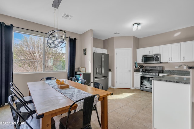 dining space featuring a notable chandelier, light tile patterned floors, visible vents, and baseboards