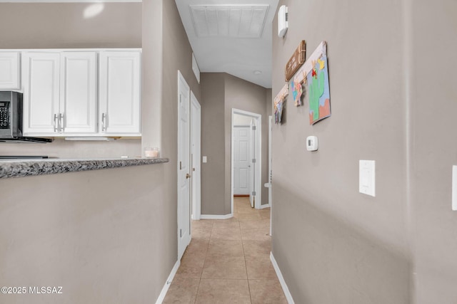 corridor with light tile patterned floors, baseboards, and visible vents