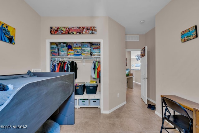 tiled bedroom with visible vents, a closet, and baseboards