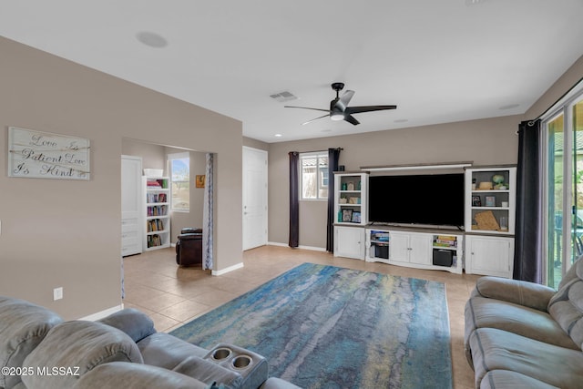 living room with light tile patterned floors, visible vents, baseboards, and a healthy amount of sunlight
