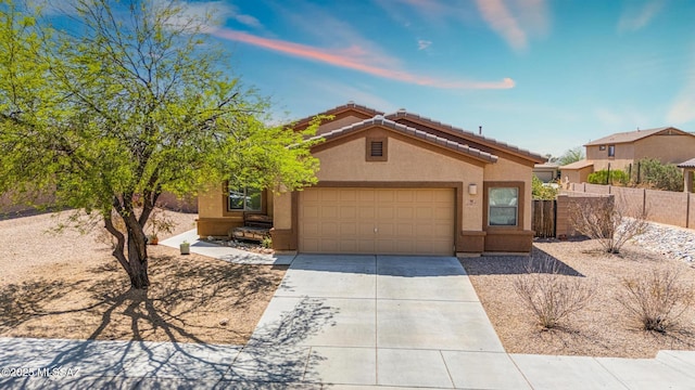 view of front facade with stucco siding, driveway, a tile roof, a garage, and fence