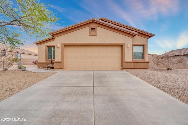 view of front of house featuring an attached garage, fence, driveway, and stucco siding