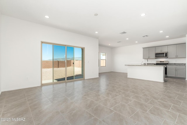 unfurnished living room featuring recessed lighting, light tile patterned floors, and visible vents