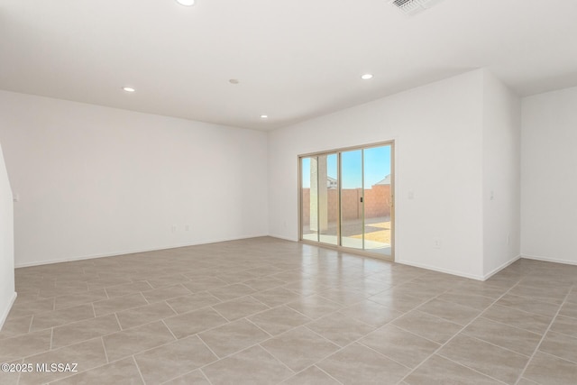 empty room with recessed lighting, visible vents, and baseboards