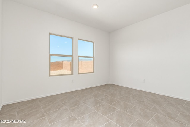 unfurnished room featuring recessed lighting and baseboards