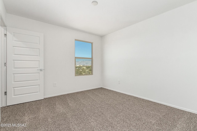 carpeted empty room featuring baseboards