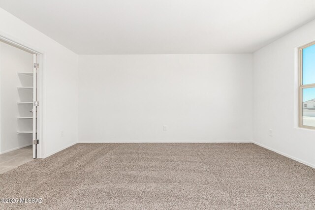 empty room with baseboards and light carpet