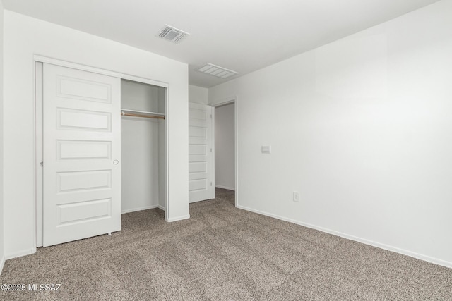 unfurnished bedroom featuring a closet, carpet flooring, baseboards, and visible vents