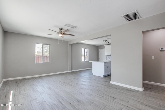 unfurnished living room featuring ceiling fan, baseboards, and visible vents
