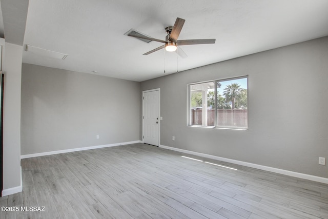 spare room featuring visible vents, baseboards, a ceiling fan, and wood finished floors