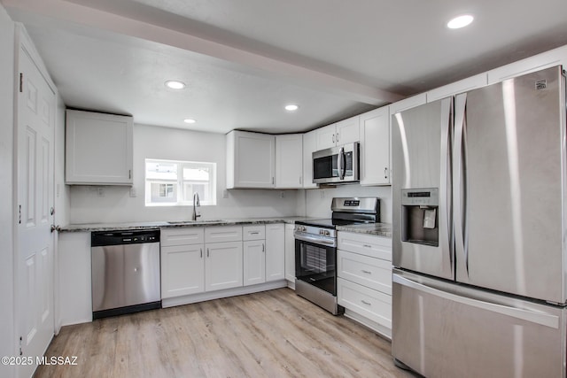 kitchen with stainless steel appliances, recessed lighting, a sink, and light stone counters