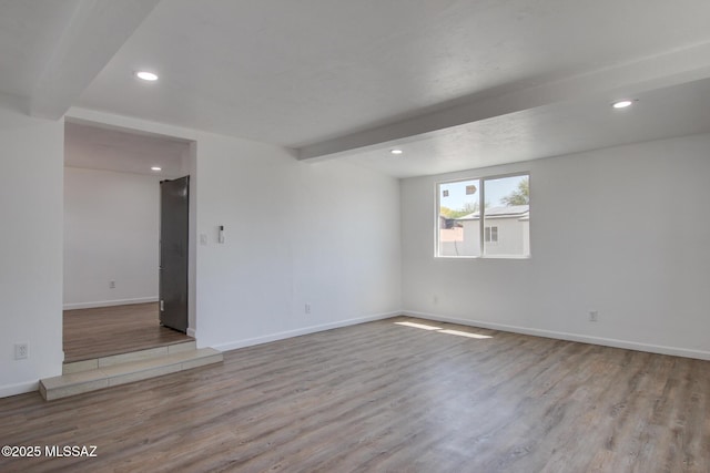 empty room featuring wood finished floors, beamed ceiling, baseboards, and recessed lighting