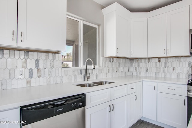 kitchen with a sink, light countertops, stainless steel dishwasher, and white cabinetry