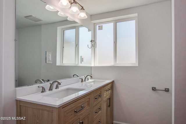 full bath with double vanity, a sink, and visible vents