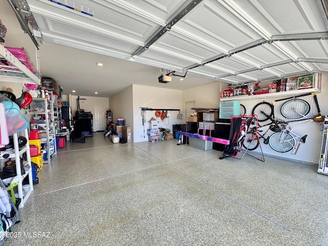 garage with a garage door opener and recessed lighting