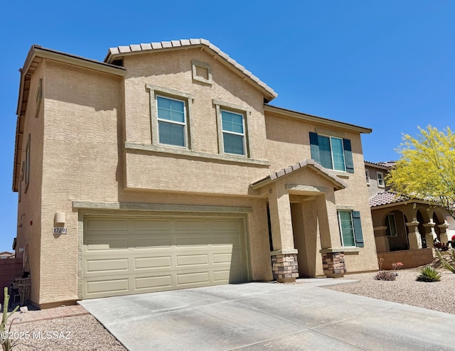 view of front of home featuring an attached garage, stucco siding, driveway, and a tile roof