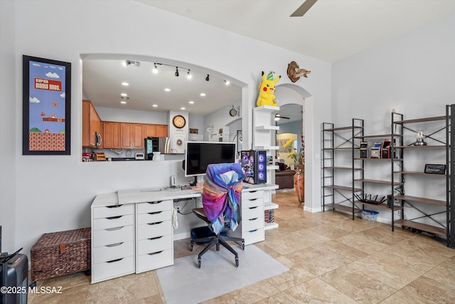 office area featuring arched walkways and a ceiling fan