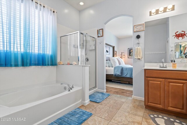 full bathroom featuring a shower stall, tile patterned flooring, vanity, ensuite bath, and a garden tub