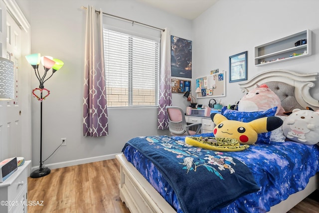 bedroom with wood finished floors and baseboards