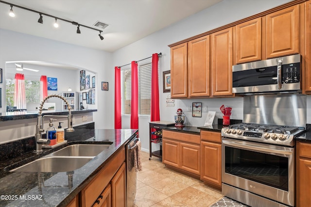 kitchen featuring brown cabinetry, visible vents, appliances with stainless steel finishes, and a sink