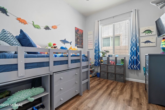 bedroom with baseboards and wood finished floors