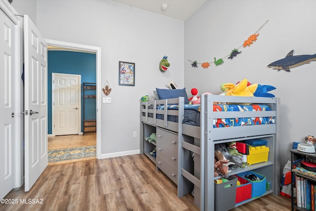 bedroom with baseboards and wood finished floors