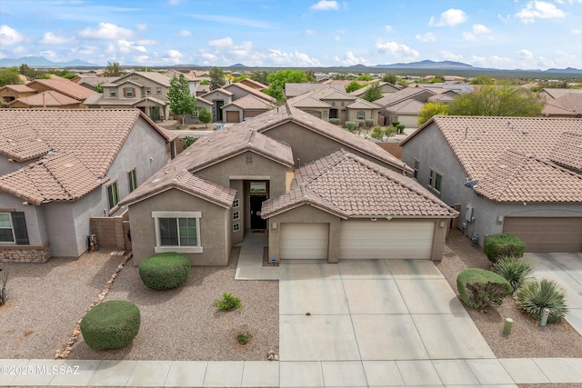 view of front facade with a tile roof, driveway, an attached garage, stucco siding, and a residential view