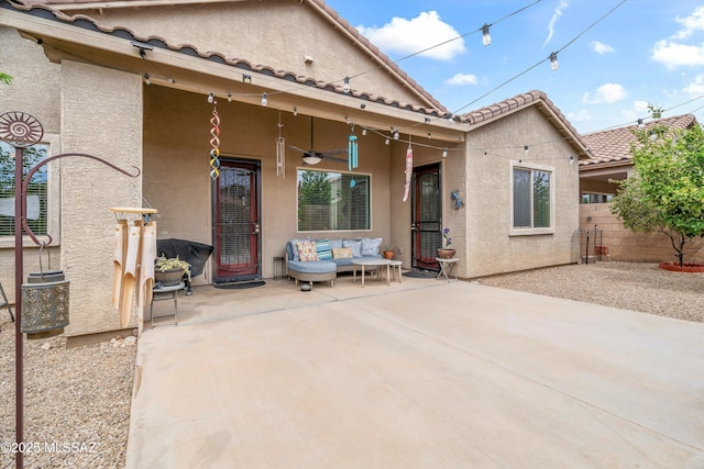 rear view of property featuring a ceiling fan, fence, stucco siding, a patio area, and an outdoor living space