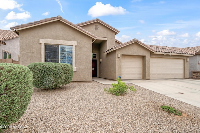 view of front facade featuring stucco siding, an attached garage, driveway, and a tile roof