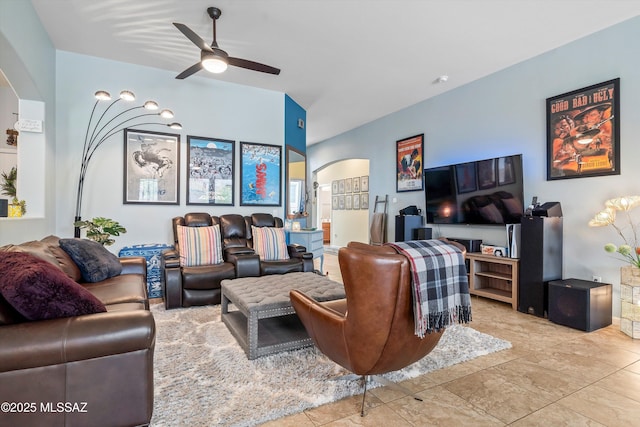 living room with a ceiling fan and arched walkways