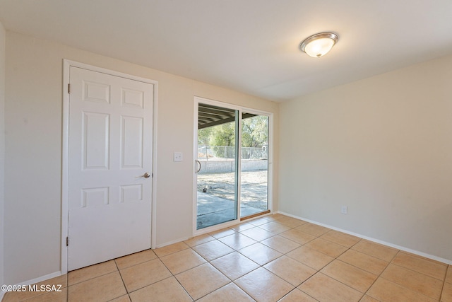 7617 E Morelos Pl, Tucson, AZ 85710 - empty room with light tile patterned floors and baseboards