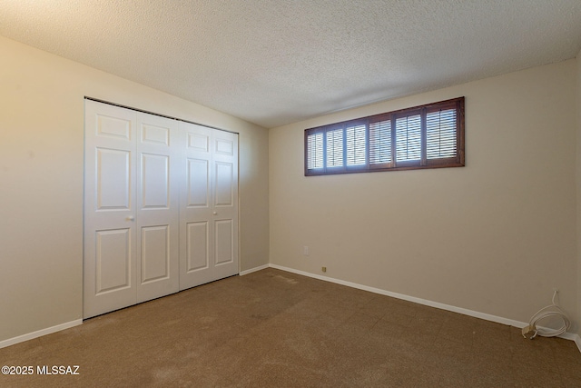 7617 E Morelos Pl, Tucson, AZ 85710 - unfurnished bedroom with a closet, baseboards, a textured ceiling, and carpet floors