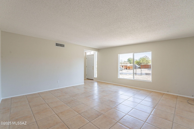 7617 E Morelos Pl, Tucson, AZ 85710 - spare room with light tile patterned floors, a textured ceiling, and baseboards