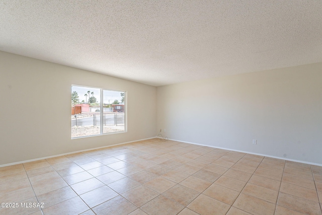 7617 E Morelos Pl, Tucson, AZ 85710 - spare room featuring light tile patterned floors, a textured ceiling, and baseboards