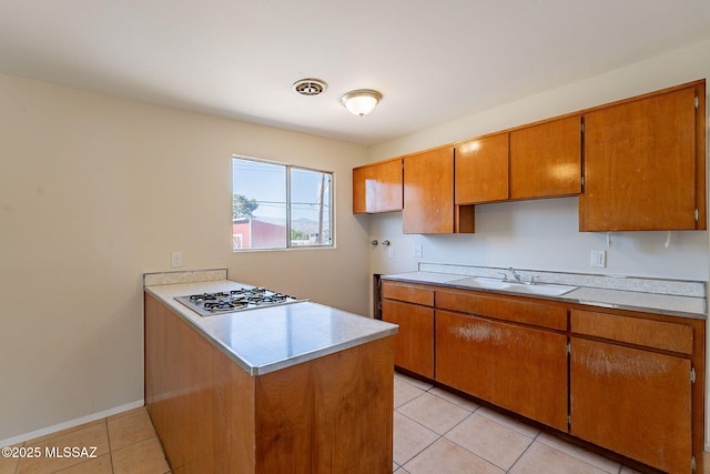 7617 E Morelos Pl, Tucson, AZ 85710 - kitchen featuring a sink, a peninsula, light tile patterned flooring, and light countertops