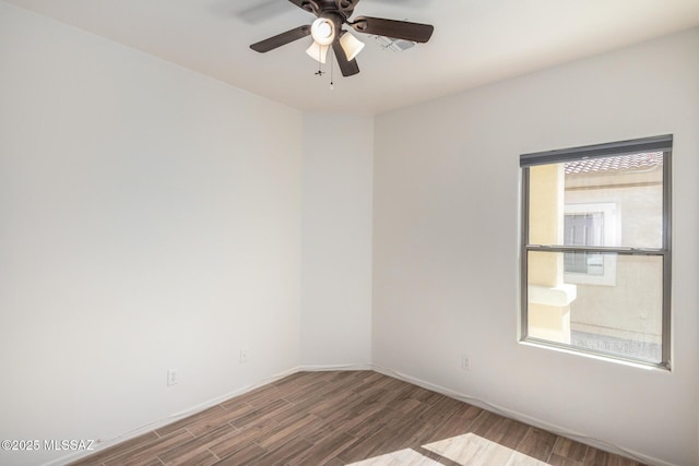 spare room with baseboards, ceiling fan, and wood finished floors