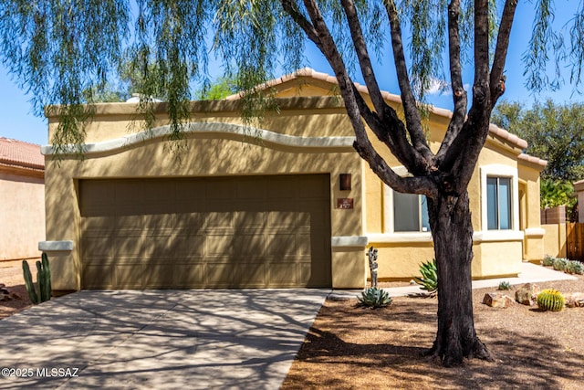 view of front of house with stucco siding, an attached garage, driveway, and a tiled roof