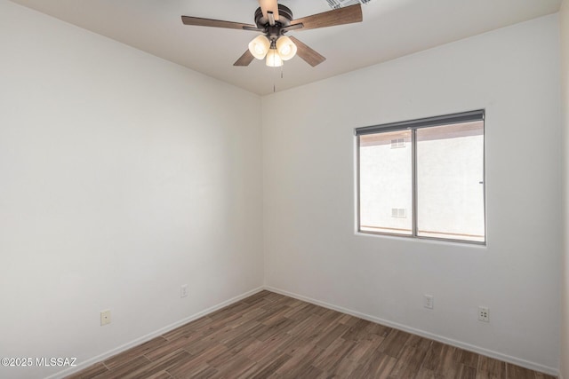 spare room featuring a ceiling fan, baseboards, and wood finished floors