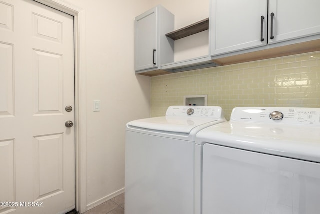 washroom with cabinet space, separate washer and dryer, tile patterned floors, and baseboards