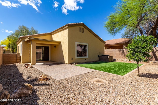 back of house featuring a patio, a tile roof, a fenced backyard, and stucco siding