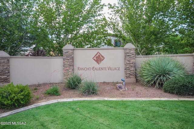 community sign with a lawn and fence